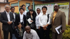 The group posed in front of the Riruta Health Centre, together with (back row from right to left) Mr. Joseph Kagiri from Pricewaterhouse Coopers (representing the Kenya country mechanism team of the Global Fund), Dr. Osamu Kunii of the Global Fund, Sister Wanjiru Kimita, the nursing officer in charge, and the delegation (with the group's advisor Prof. Satoru Watanabe).